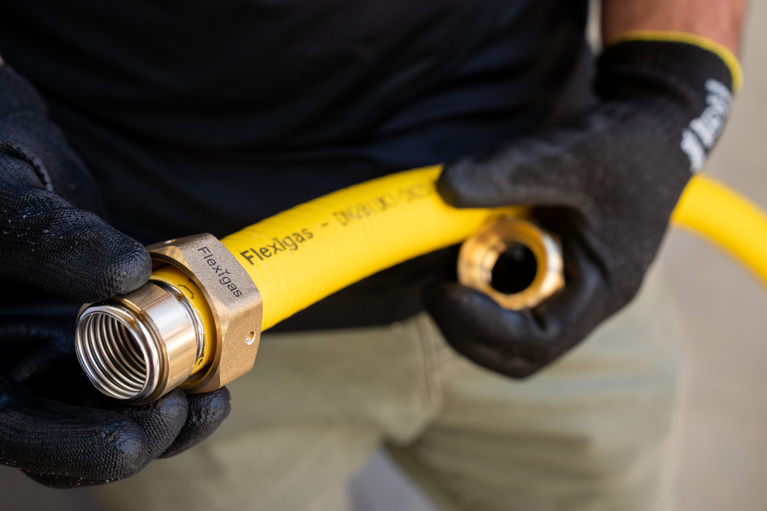 Sliding the brass nut and collets onto the Flexigas tube ready for the fitting